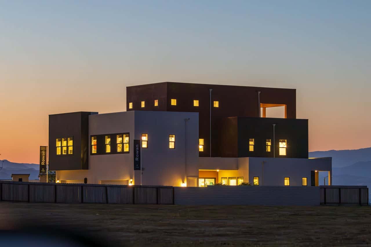 A home at dusk with every window lit.
